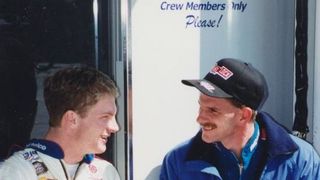 Dale Earnhardt Jr. and brother Kerry exchange thoughts in the garage area.